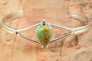 Genuine Manassa Turquoise set in Sterling Silver Bracelet. This Turquoise is also referred to as King�s Manassa Turquoise. The Manassa Turquoise mine is located in Manassa, Conejos County, Colorado. Created by Navajo Artist Lucy Valencia. Signed L. J. by the artist.